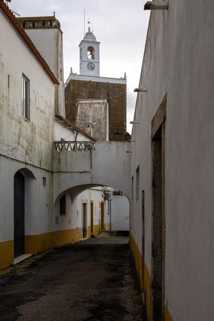 Rua dos Arcos, com arco e casas caiadas com barras amarelas